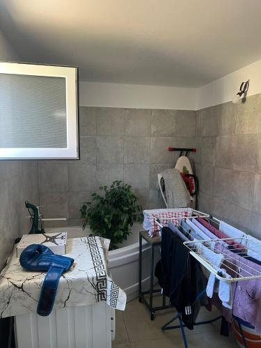 a room with a bath tub and a table with clothes at Casa Rodica in Mangalia