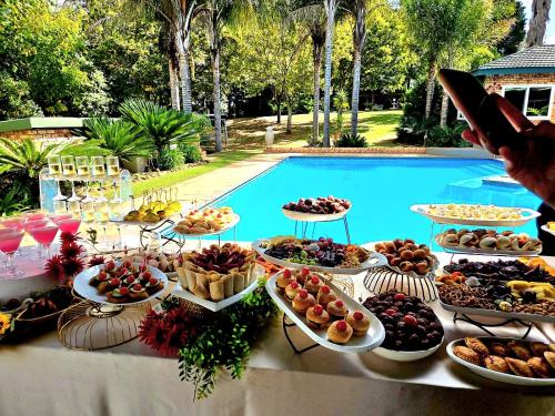 a buffet of food on a table next to a pool at Sunrise Serenity Guest House in Lydenburg