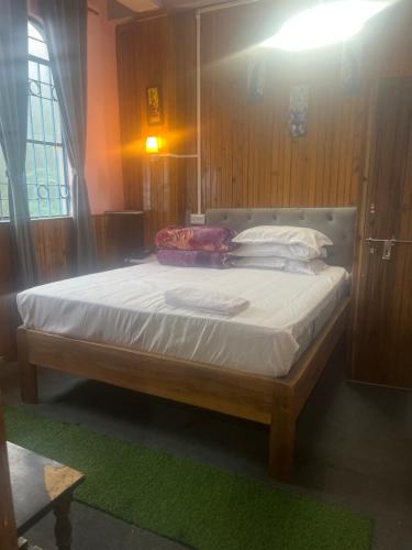 a bedroom with a large bed with white sheets at The Rainbow Inn in Sonāda