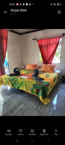 a bedroom with a bed with a colorful comforter at Terai vahine lodge in Rangiroa
