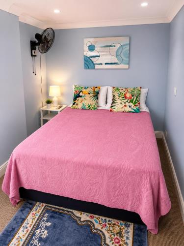 a bedroom with a pink bed with a pink comforter at Veronika Double Room in London