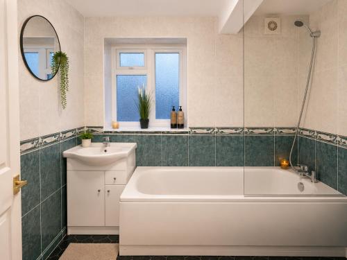 a bathroom with a white tub and a sink at Veronika Double Room in London