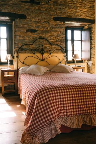 a bedroom with a large bed in a brick wall at Hotel Rural El Conceyu in Cabanella