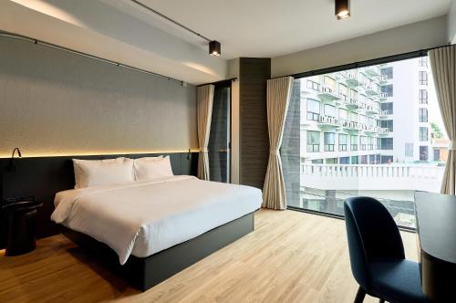 a bedroom with a bed and a large window at Lantern Chiang Mai Night Bazaar Hotel in Chiang Mai