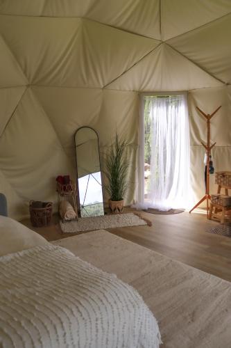 a bedroom with a bed in a tent at Glempingosta in Bauska