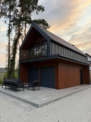 a building with two benches in front of it at Black House in Sława