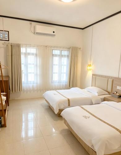 a hotel room with three beds in it at Tea time B&B 叙茶时光客栈 in Luang Prabang