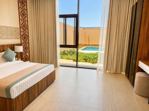 a bedroom with a bed and a view of a pool at منتجع ليورا ــ Liora Resort in Al Ḩanī