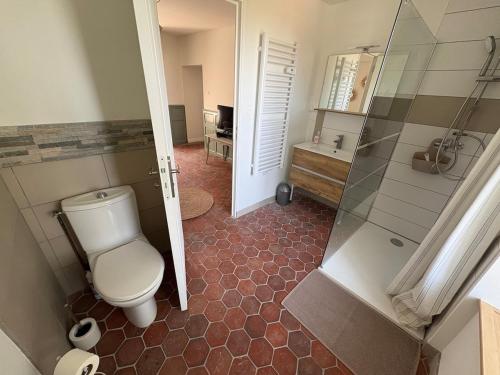 a bathroom with a toilet and a walk in shower at Logis de l'Éperon Laon in Laon
