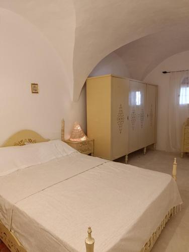 a bedroom with a large white bed and a window at Dar Toubib in Qaşr Chouline