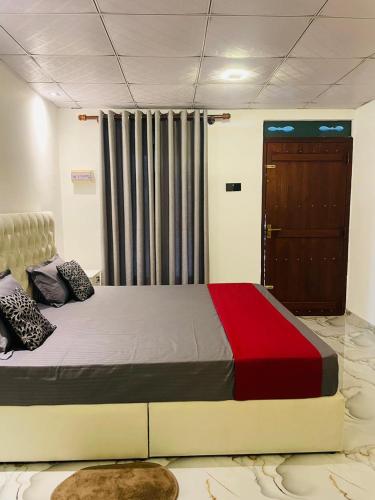a bedroom with a large bed with a red blanket at Coastal Bliss in Dickwella