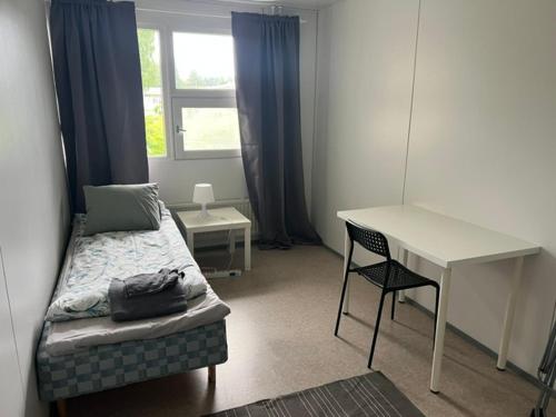 a bedroom with a bed and a desk and a window at Ravikatu, Oulainen, in Oulainen