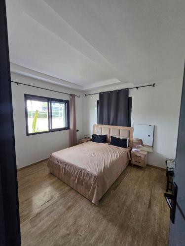 a bedroom with a large bed and a window at Appartement RDJ in Dar Hamida