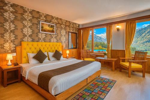 a bedroom with a bed with a view of a mountain at The Ganga lodge, Manali - Affordable Luxury Stay Near Mall Road Manali in Manāli