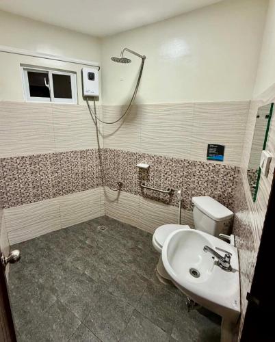 a bathroom with a toilet and a sink and a shower at Mongki's Pension House in Puerto Princesa City