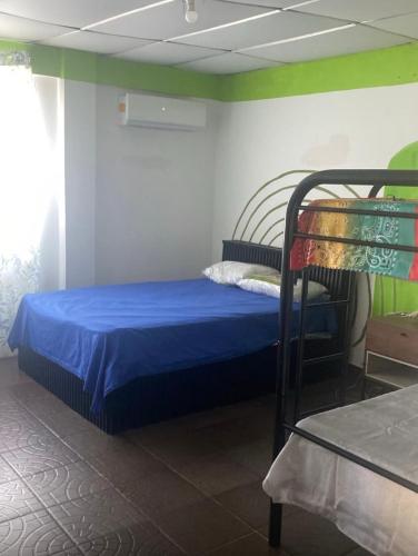 a bedroom with a bed with a blue bedsheet at Yayi Maria in Río Hato