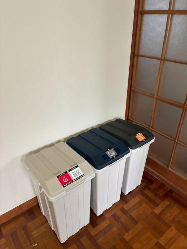 two trash cans sitting next to each other in a room at ゲストハウス美和館 in Imabari