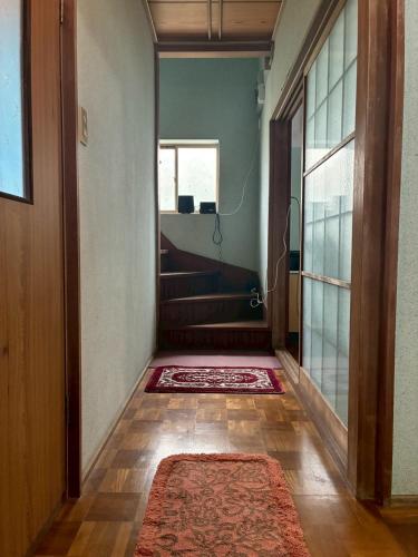 an empty hallway with a door and a rug at ゲストハウス美和館 in Imabari