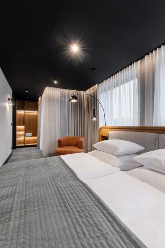 ein Hotelzimmer mit zwei Betten und einem Stuhl in der Unterkunft Hotel Kraft in Kraśnik