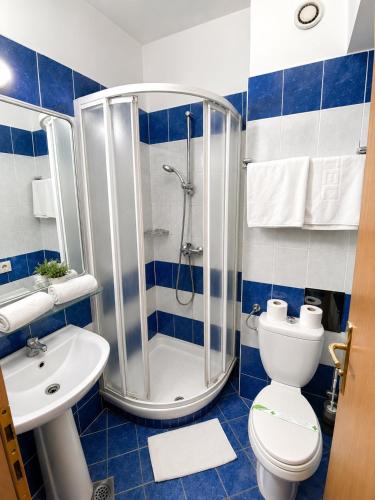 ein Badezimmer mit Dusche, Toilette und Waschbecken in der Unterkunft Hotel Orijent 22 in Laktaši