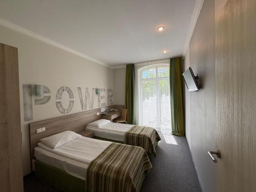 a hotel room with two beds and a window at PracticOtel Kyiv in Kyiv