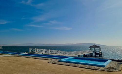 a pier with blue slides on the water at Ocean View Apartment Beach Pools Pier & Lift in Paracas