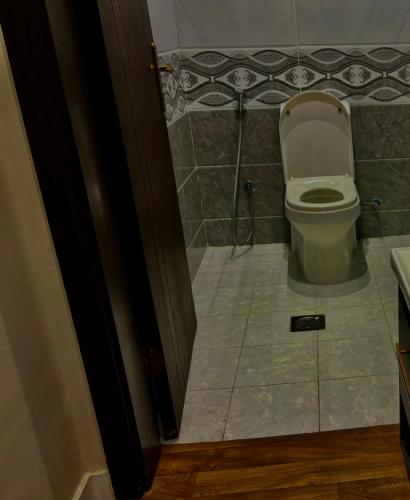 a bathroom with a toilet and a tile floor at شقة غرفة وصالة مريحة in Jeddah