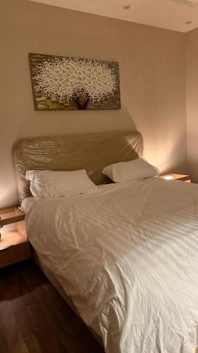 a bedroom with a white bed and a painting on the wall at شقة غرفة وصالة مريحة in Jeddah
