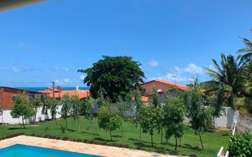 a view of a yard with trees and a swimming pool at Quartos da Mell in Beberibe