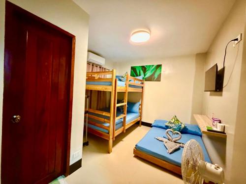 a bedroom with a bed and bunk beds with a ladder at Mongki's Pension House in Puerto Princesa City