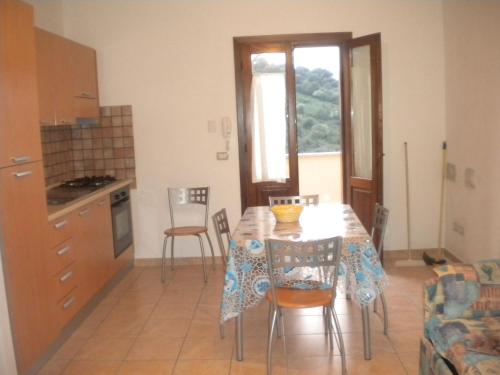 a kitchen and dining room with a table and chairs at Le case in collina - San Teodoro in Lu Lioni