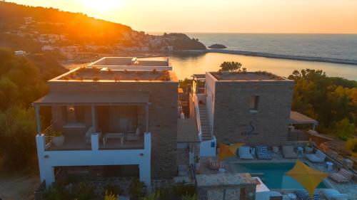 an aerial view of a house with the ocean at Sofrano Luxury Apartments in Evdilos