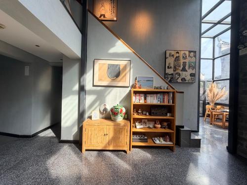 ein Zimmer mit einem Bücherregal und einer Treppe in der Unterkunft Interlude Inn, Boutique Art Retreat, Cultural Experience, Artisan Breakfast in Fenghuang