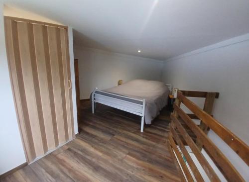 a small bedroom with a bed and a staircase at Bungalow P&P in Entre-Deux