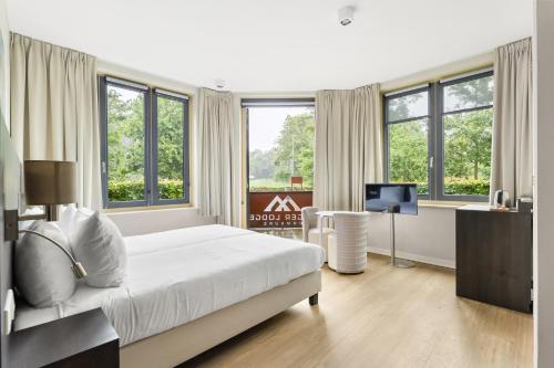 a bedroom with a bed and a tv and windows at Mezger Lodges in Domburg