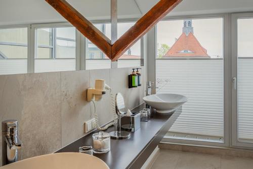 a bathroom with a sink and a mirror and window at Hotel Oderberger in Berlin