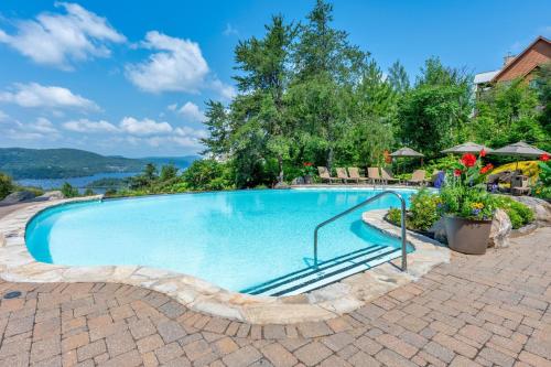 a swimming pool in a yard with chairs and flowers at Tremblant Prestige - Équinoxe 164-2 in Mont-Tremblant