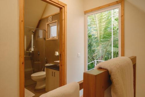 ein Badezimmer mit Toilette und Fenster in der Unterkunft ETHER Marari Beachfront in Mararikulam
