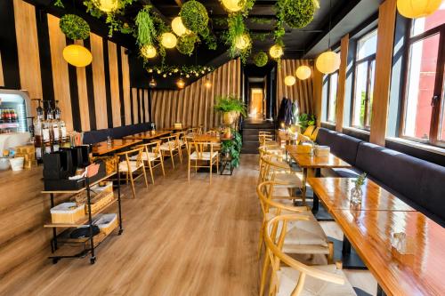 a restaurant with wooden tables and chairs and lights at Hotel Olimp in Cluj-Napoca