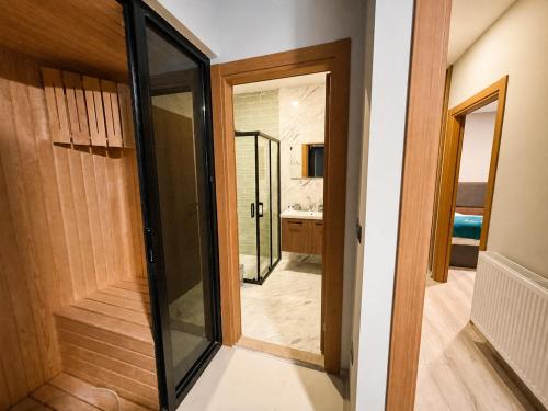a hallway with a glass door leading to a bathroom at Uzungol Ada Bungalow in Uzungöl