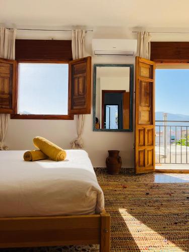 a bedroom with a bed with a view of the ocean at Peaceful Townhouse Retreat in Órgiva