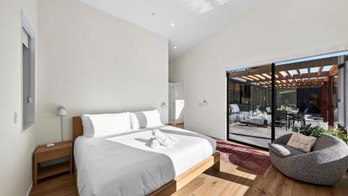 a bedroom with a large bed and a chair at Olive Oak by AvantStay in Glen Ellen