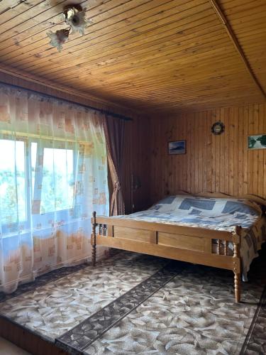 a bed in a room with a wooden ceiling at Буркут in Yaremche