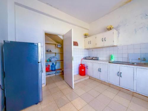 a kitchen with a blue refrigerator in a room at Oceana Villa in Mombasa