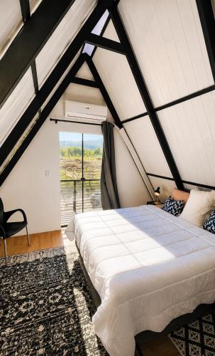 a large bed in a room with a window at Cabaña Alpina - Ecos del Cerro in Paraguarí