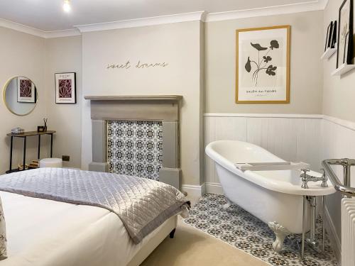 a bedroom with a bed and a tub and a sink at Olive Cottage in Barnard Castle