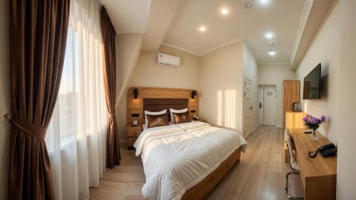 a bedroom with a large bed and a window at Art Moderno Hotel in Tashkent