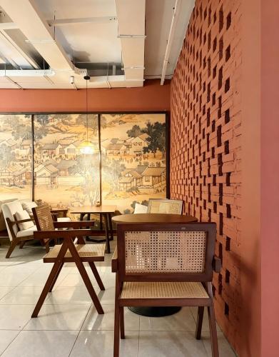 a restaurant with tables and chairs and a large mural at Tea time B&B 叙茶时光客栈 in Luang Prabang