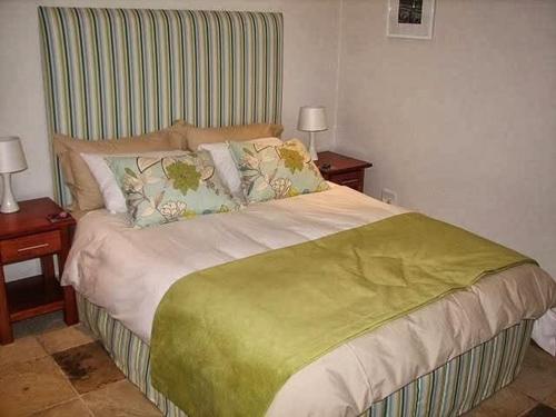 a bedroom with a large bed with a striped headboard at Avocado Grove Guest House in White River