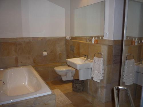 a bathroom with a sink and a toilet and a tub at Avocado Grove Guest House in White River